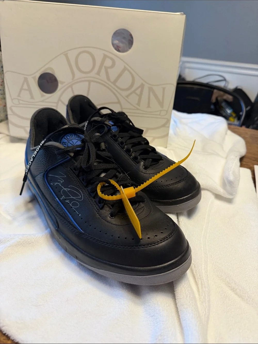 Air Jordan 2 Retro Low Black Sneakers with MJ’s signature and tag.
